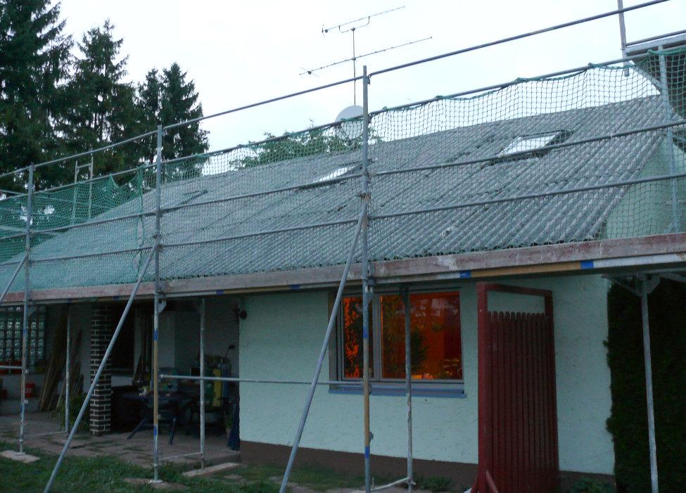 Ein altes Haus mit einem Blechdach und einem Gerüst drum herum