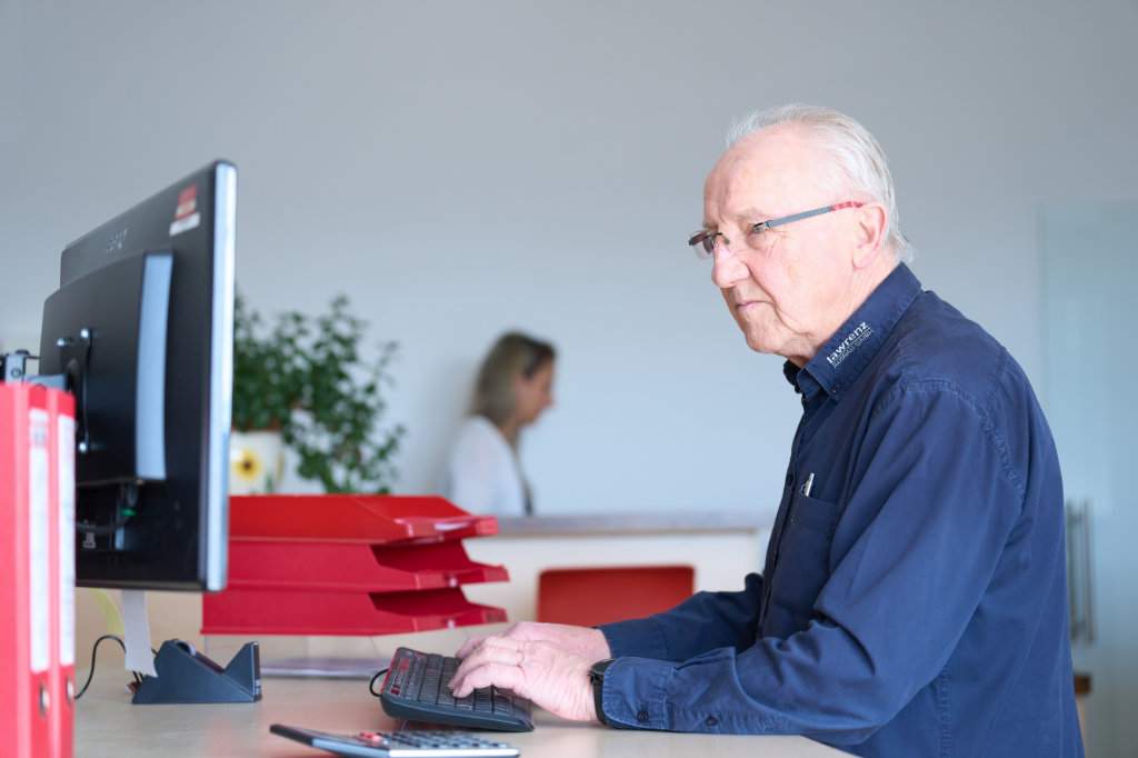 Ein Mann in einem Büro, der sich auf seinen Computerbildschirm konzentriert