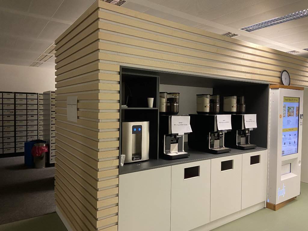 Ein Pausenbereich mit holzverkleideten Wänden und Kaffeemaschinen